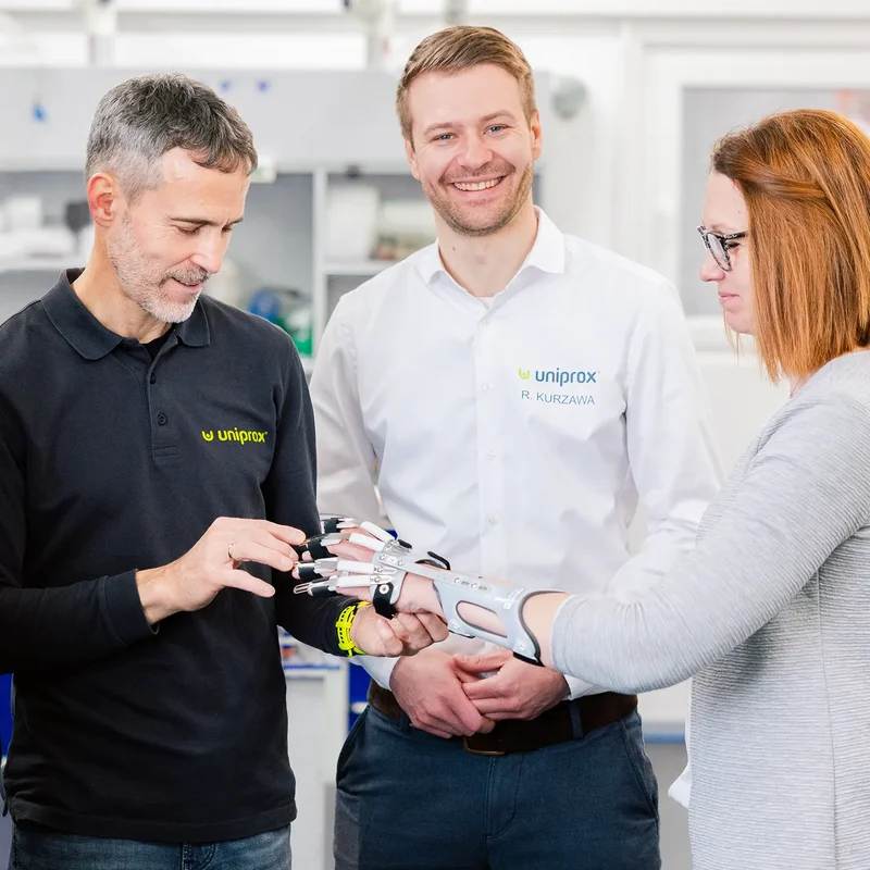 Orthopädietechniker von Uniprox passen eine moderne Handprothese an und erklären Funktionen im Beratungsgespräch